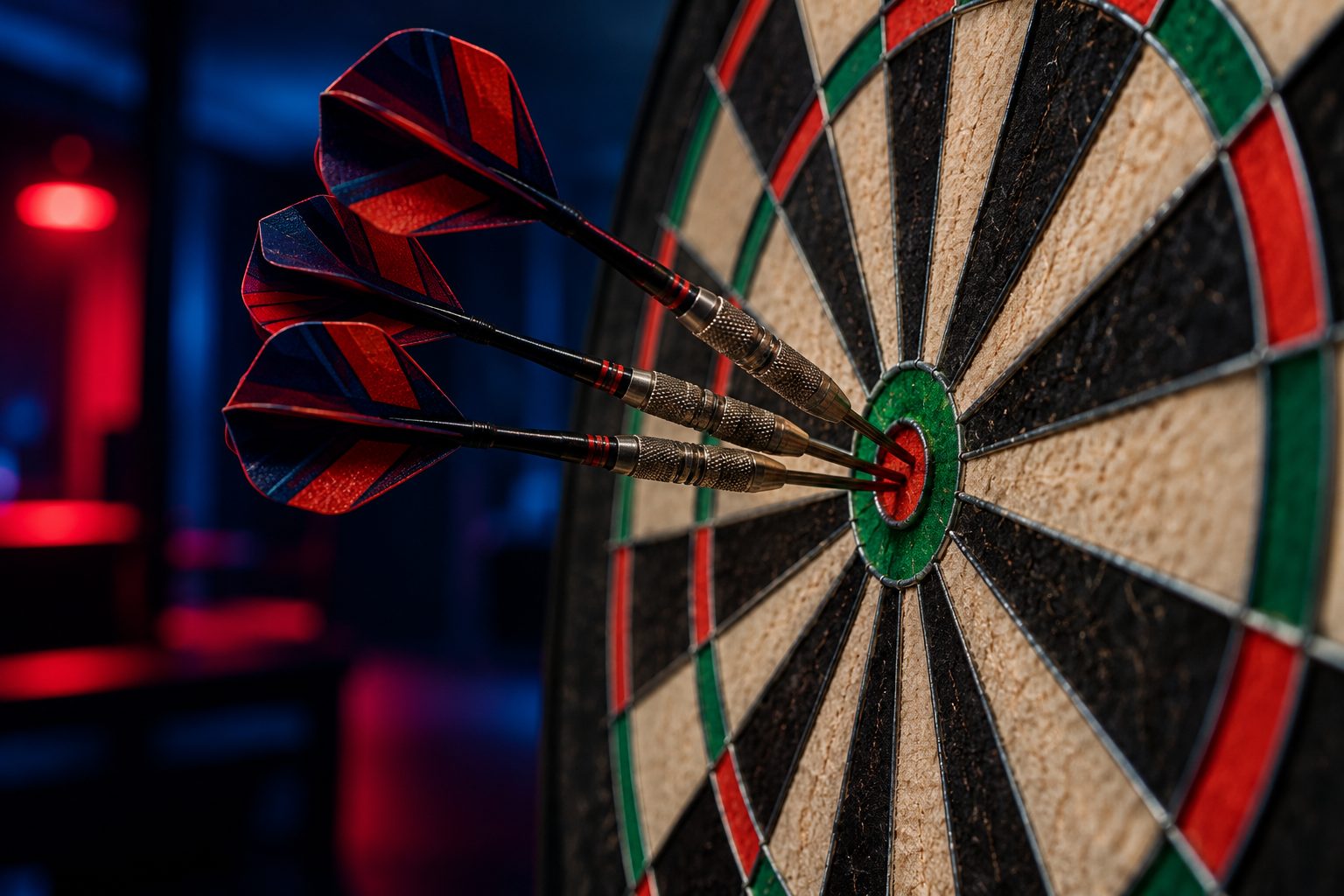 Three darts with red and navy flights in the bullseye of a dartboard