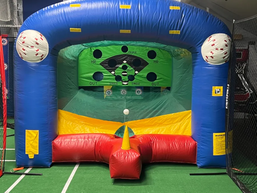 An inflatable baseball target game set up in the arena